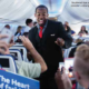 Flight Attendant walks through plane.